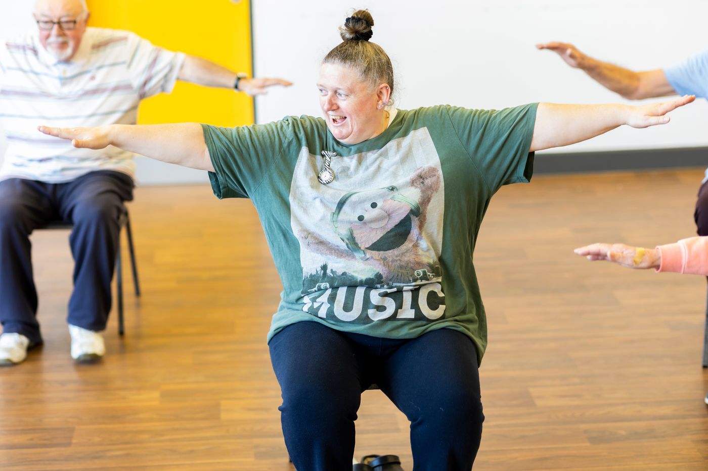 A seated exercise group stretching together